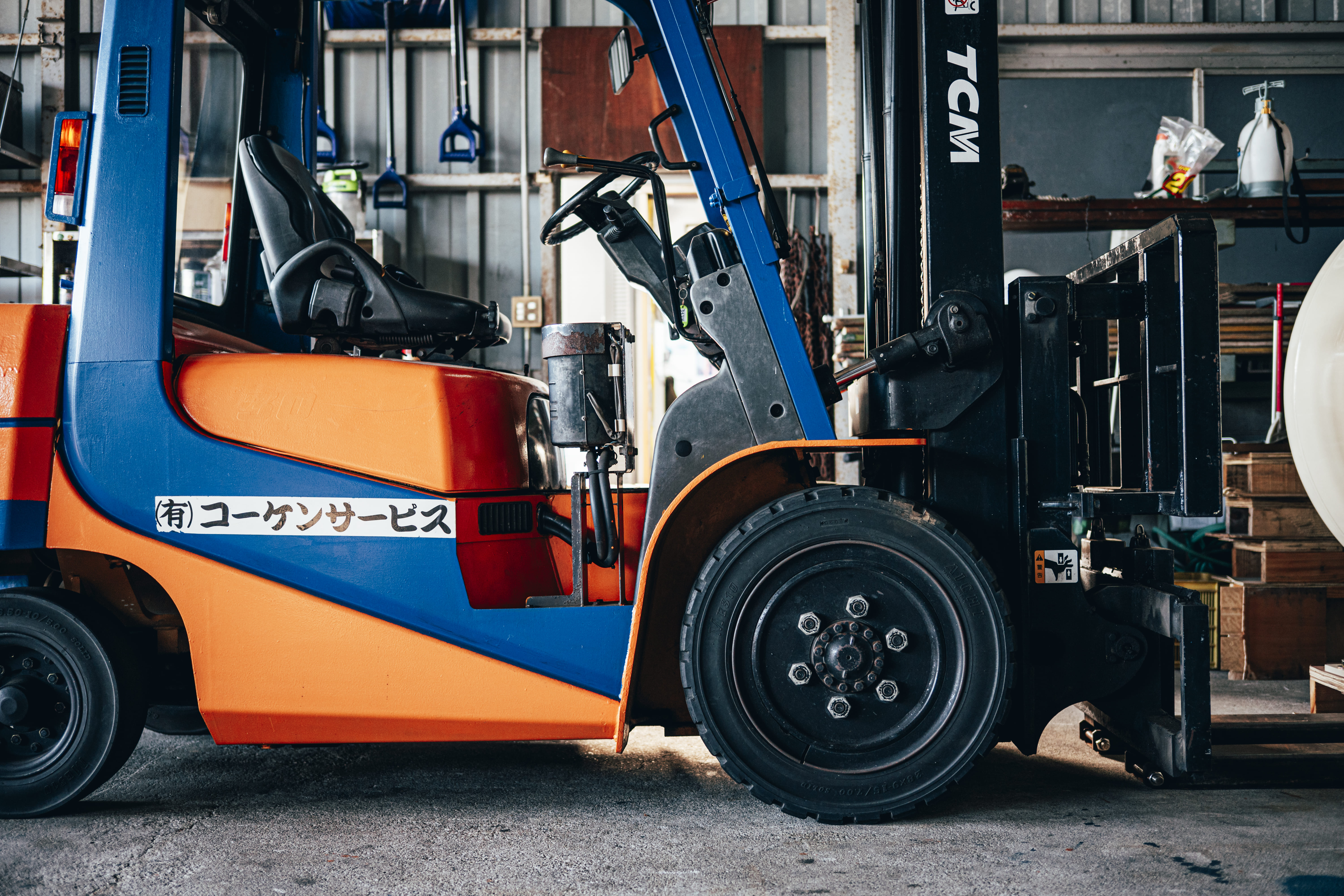 赤いフォークリフトを運転する作業員