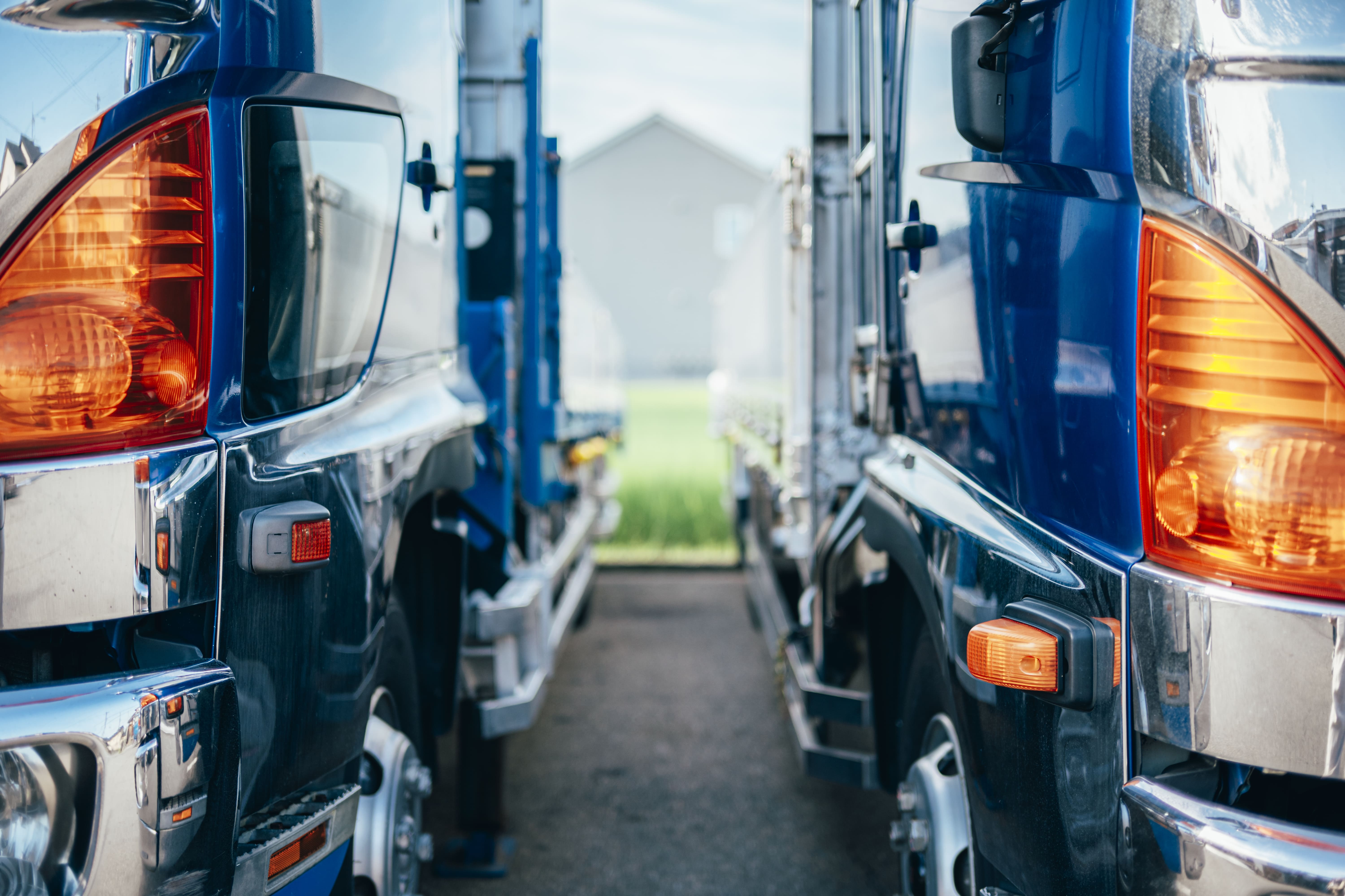 白いトラックが2台立ち並んでいます