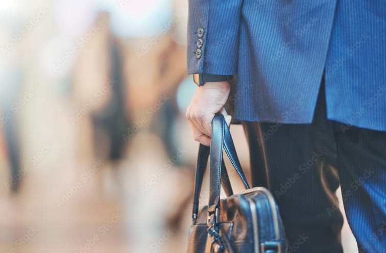 スーツの男性がバックを持っている手元の写真です